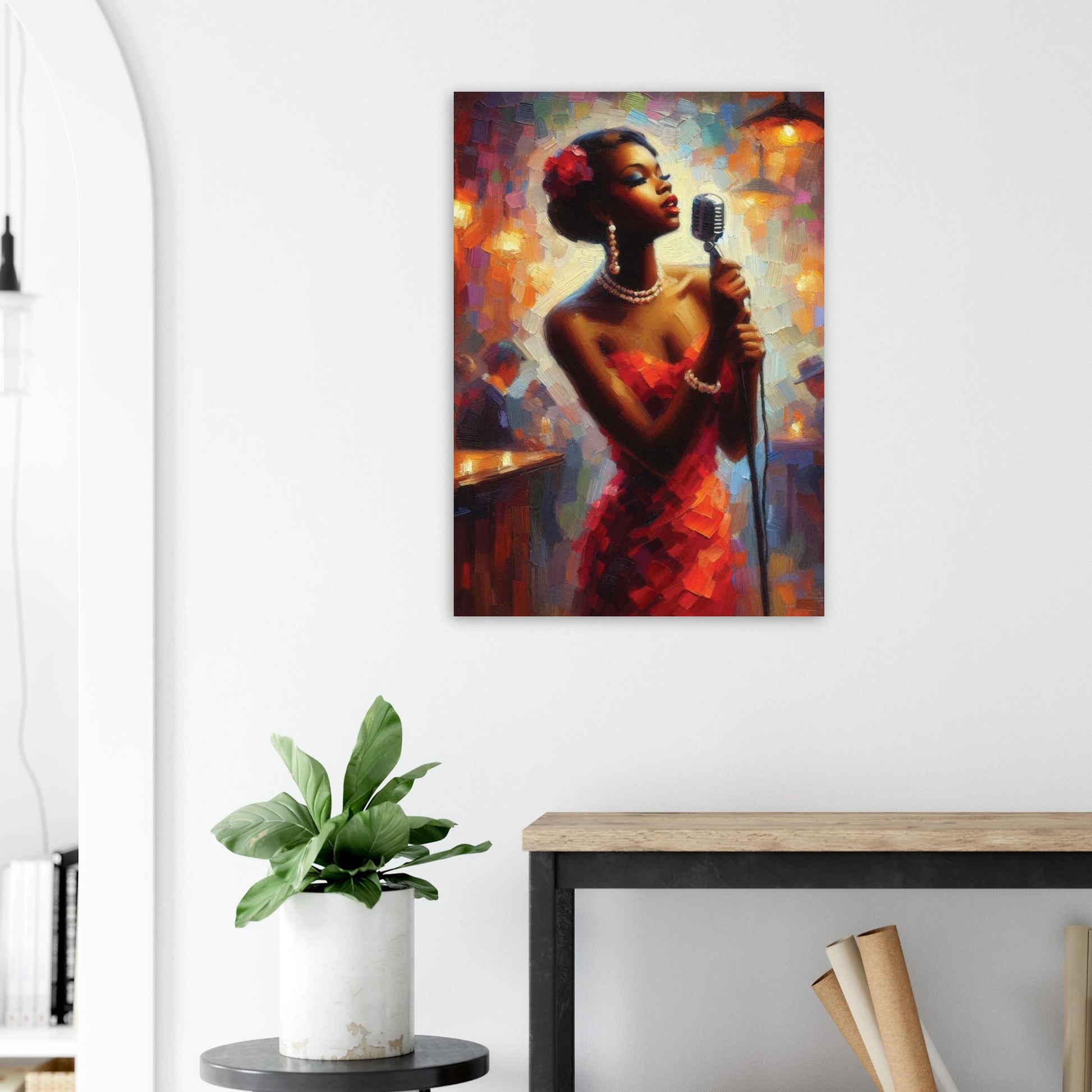 Art print of a woman holding a microphone on a wall above a desk with a plant.